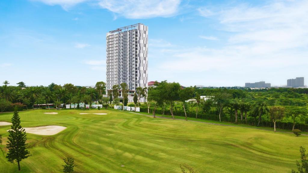 un parcours de golf avec un grand bâtiment en arrière-plan dans l'établissement Kawana Golf Residence, à Cikarang