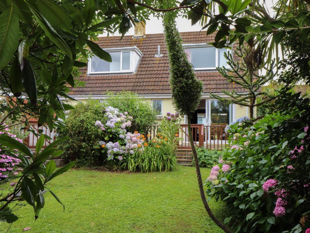 ein Garten vor einem Haus mit Blumen in der Unterkunft Pencoys in Helston