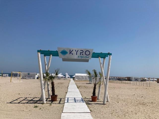 a sign on the beach with palm trees under it at Selen Apartment-Faleza Nord in Constanţa