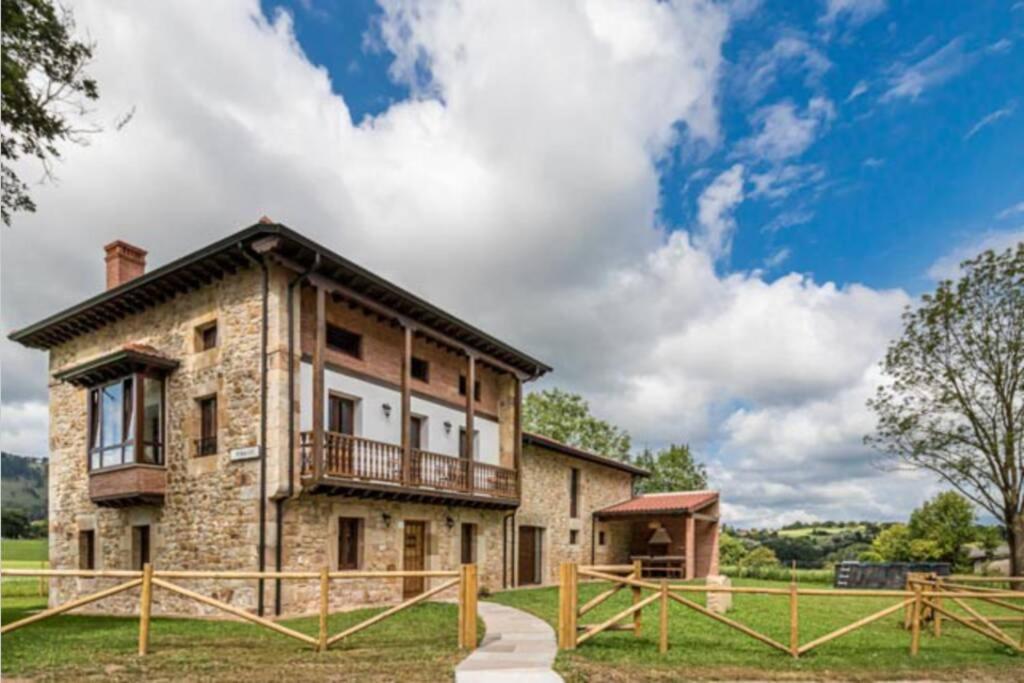 Casa de piedra con balcón en la parte superior. en Espectacular villa rural en Cabárceno en Penagos