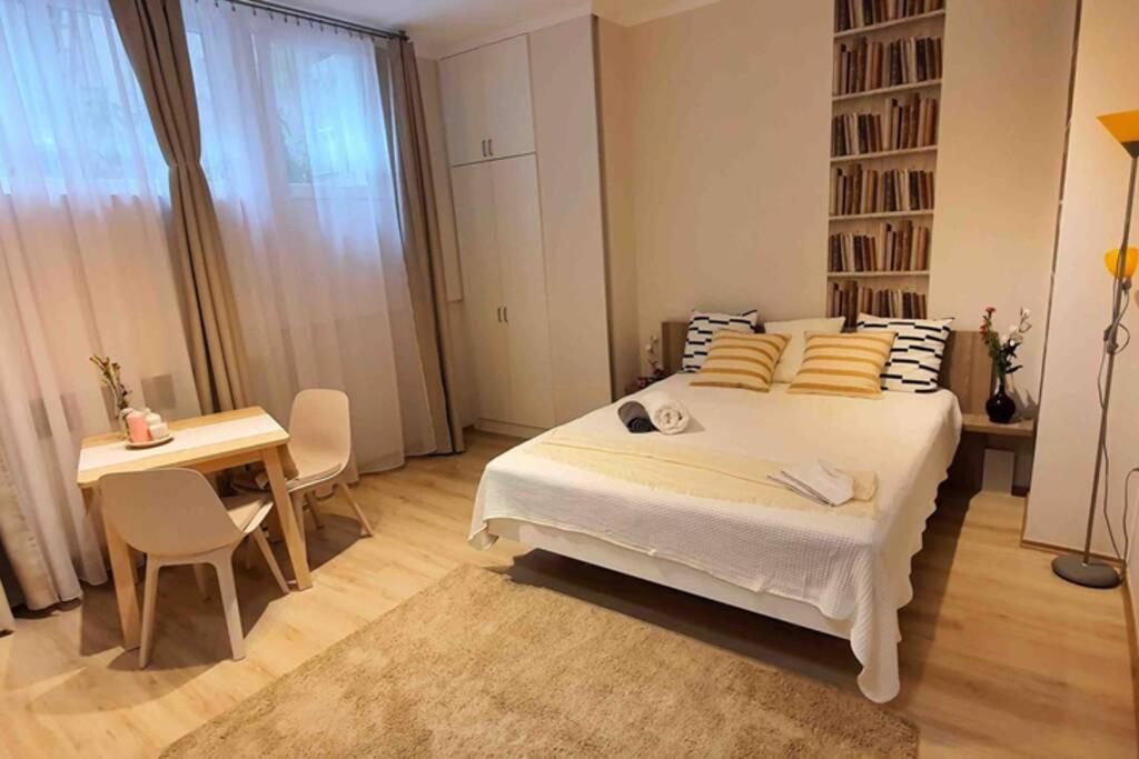 a bedroom with a bed and a table and a desk at Studio flat in the center of Budapest in Budapest