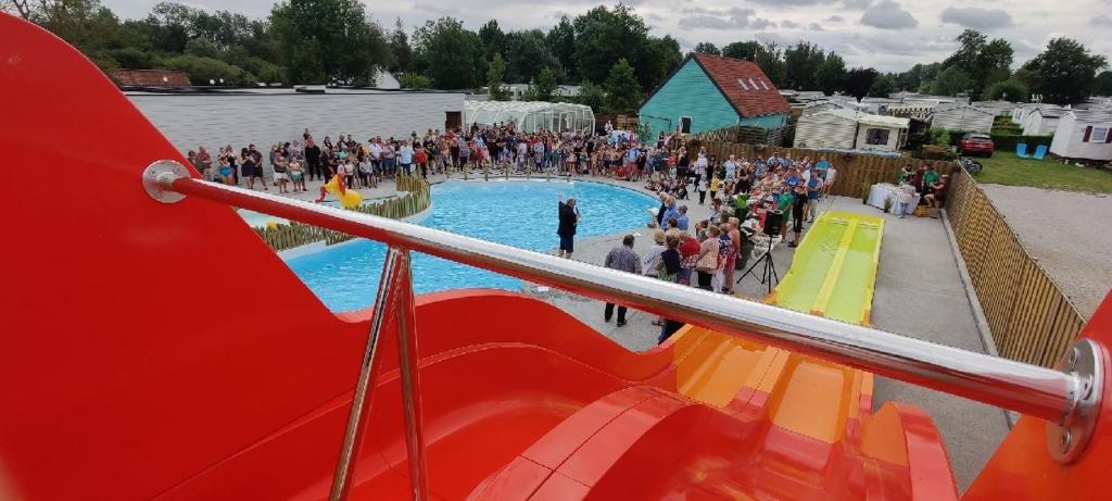 una multitud de personas de pie alrededor de una piscina en Camping et Gîte La Garenne de moncourt baie somme, en Rue