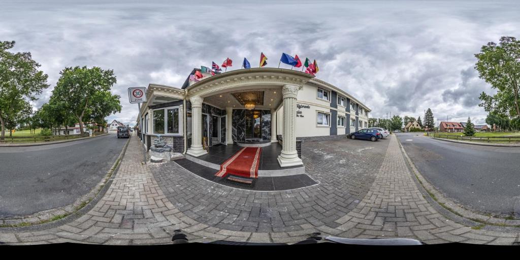 un edificio en una calle con banderas. en Hotel Ristorante Sicilia, en Tappenbeck