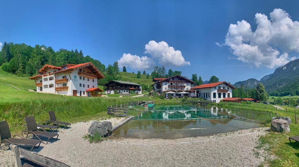 ein Resort mit einem Pool und einigen Häusern in der Unterkunft Naturhotel Reissenlehen in Bischofswiesen