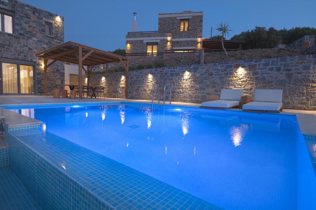 una piscina en una villa por la noche en Acantha Villas, en Mókhlos