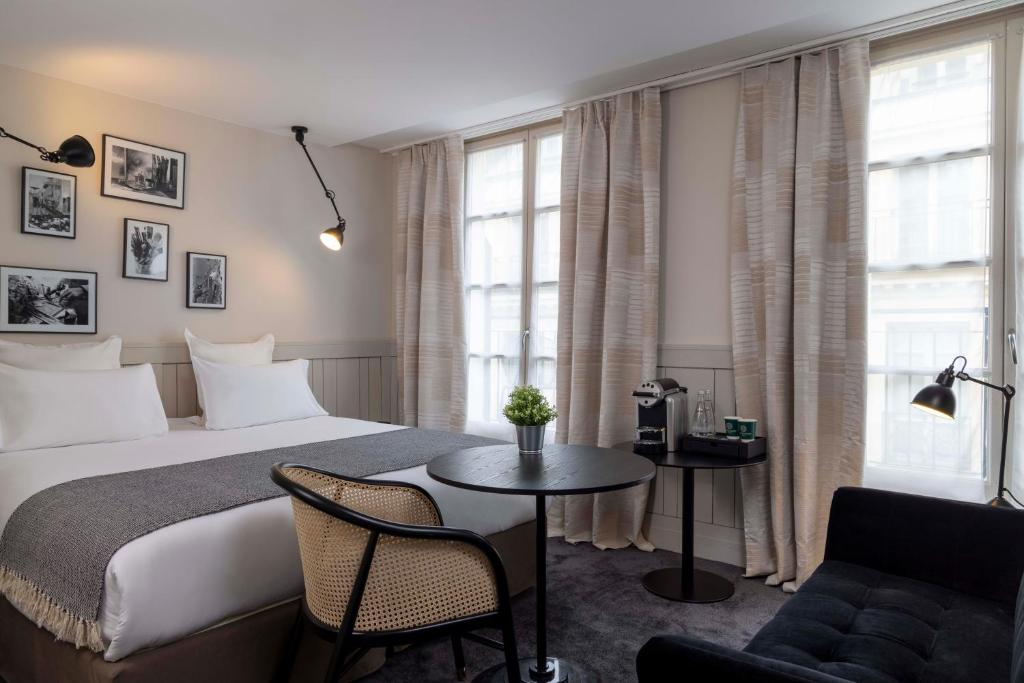a hotel room with a bed and a table at Hôtel Hélios Opéra in Paris