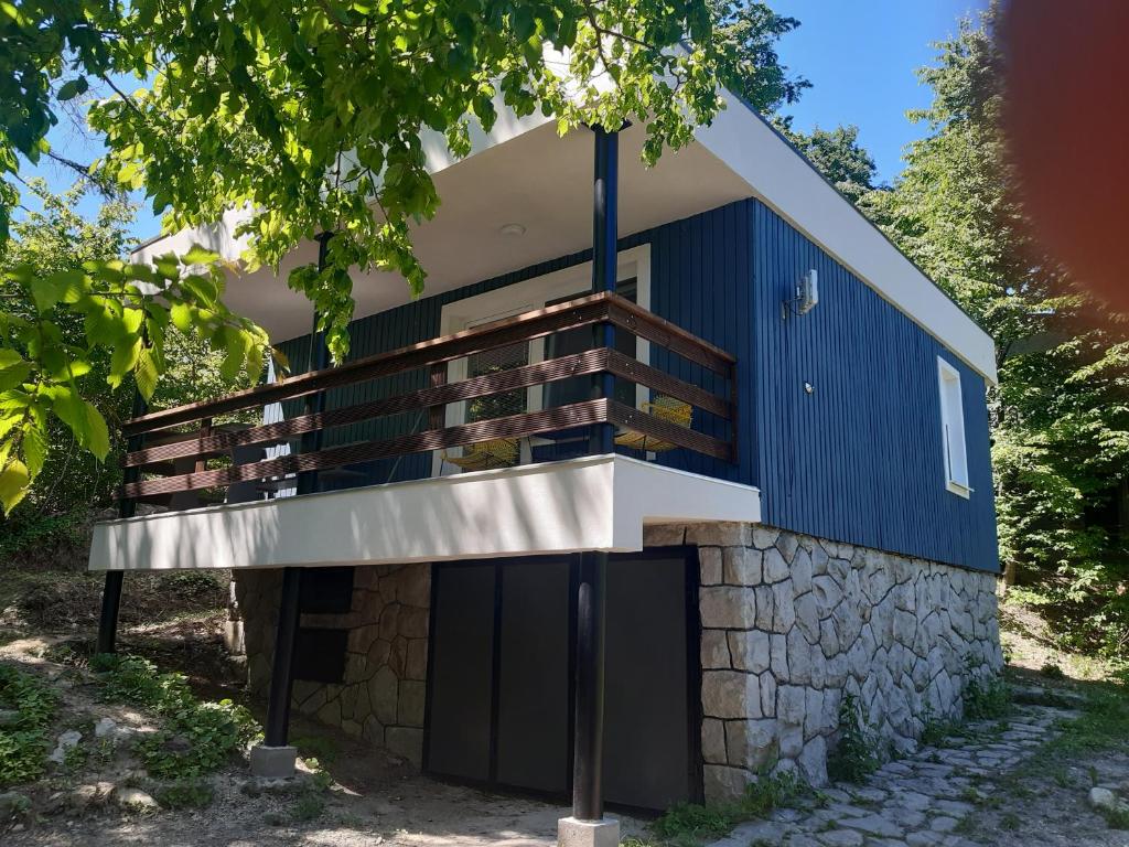 une maison construite sur un mur en pierre avec un balcon dans l'établissement chata Modrá, à Vinné