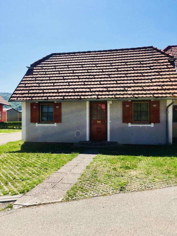 a small white house with a red door at Apartmán Perspekta 196 in Čatež ob Savi