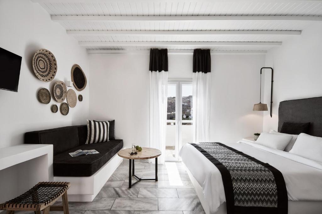 a hotel room with a bed and a couch at Mr & Mrs White Mykonos in Platis Gialos