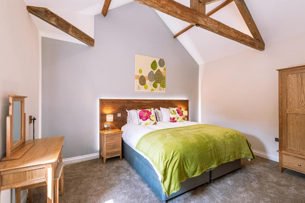 a bedroom with a large bed and a wooden desk at Brecks Farm - The Mill in York