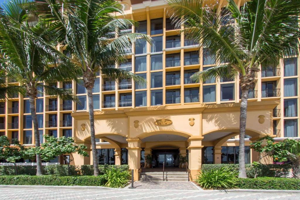 a building with palm trees in front of it at Wyndham Deerfield Beach Resort in Deerfield Beach