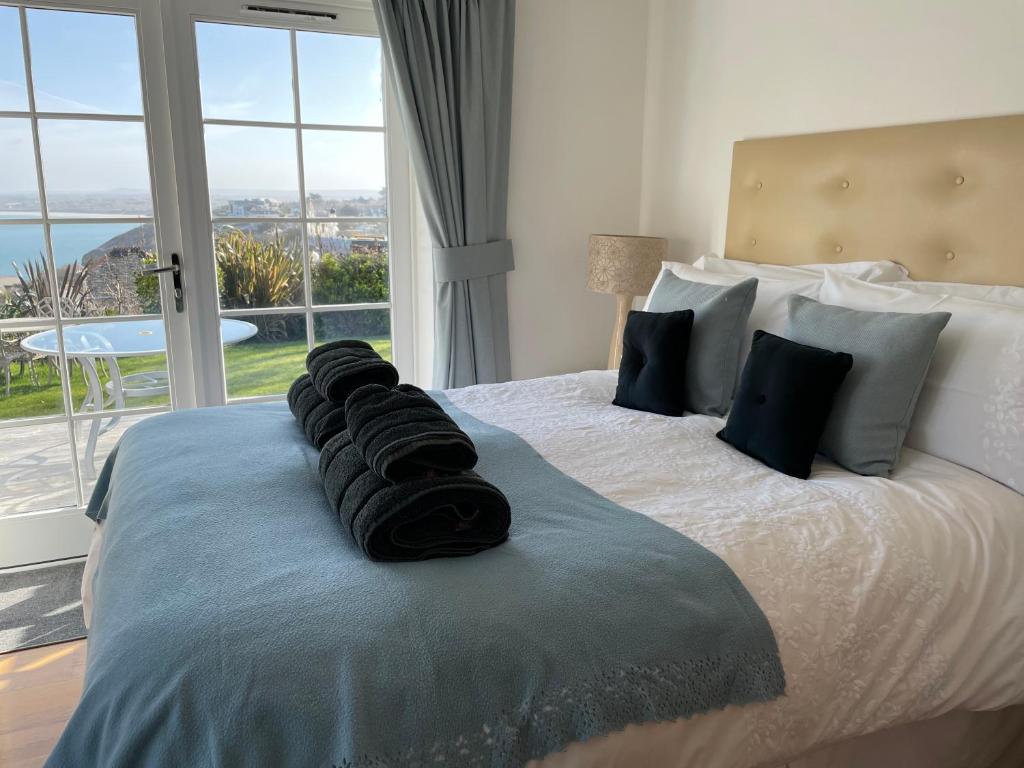 a bedroom with a large bed with a large window at Seaside Apartment in Carbis Bay