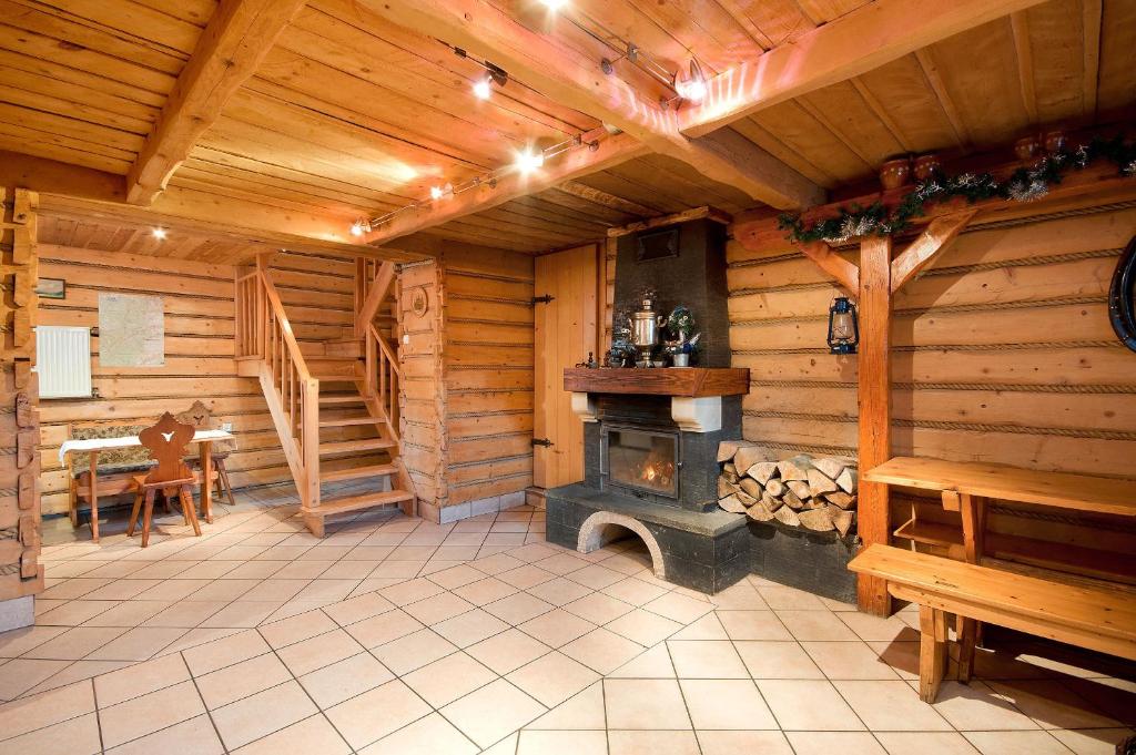 a large room with a fireplace in a log cabin at Dom Narciarza in Szczyrk