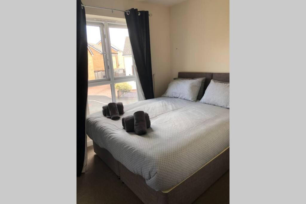 Un dormitorio con una cama con dos zapatos encima. en Dudley House **Staycation & Contractors** Sleeps 7, en Tipton