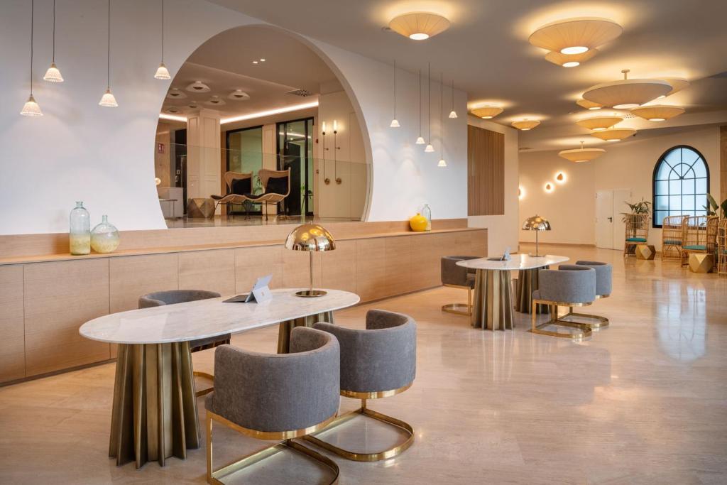 a lobby with two tables and chairs and a counter at Arrecife Gran Hotel & Spa in Arrecife