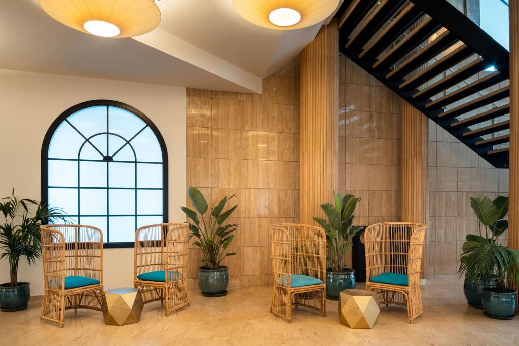 a group of chairs in a room with plants at Arrecife Gran Hotel & Spa in Arrecife