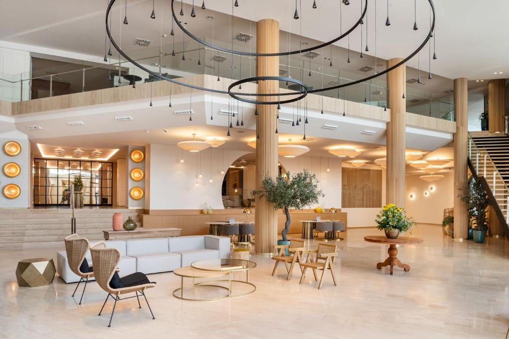 a lobby with a large chandelier and tables and chairs at Arrecife Gran Hotel & Spa in Arrecife