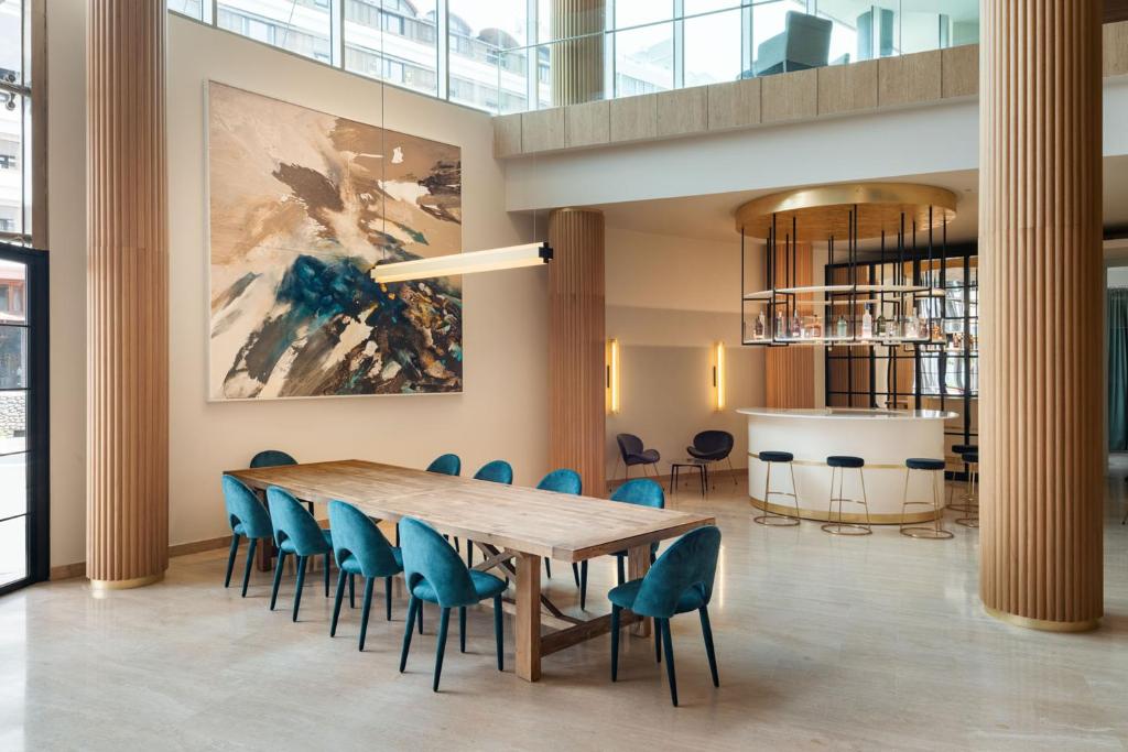 a conference room with a wooden table and blue chairs at Arrecife Gran Hotel & Spa in Arrecife