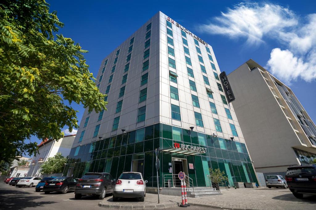 a tall building with cars parked in front of it at Hotel CH Bucharest in Bucharest