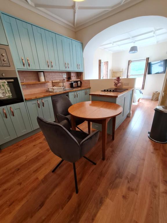 a kitchen with a table and a chair in a room at Kylemore House boutique apartments - Fishermans Perch in Kylemore