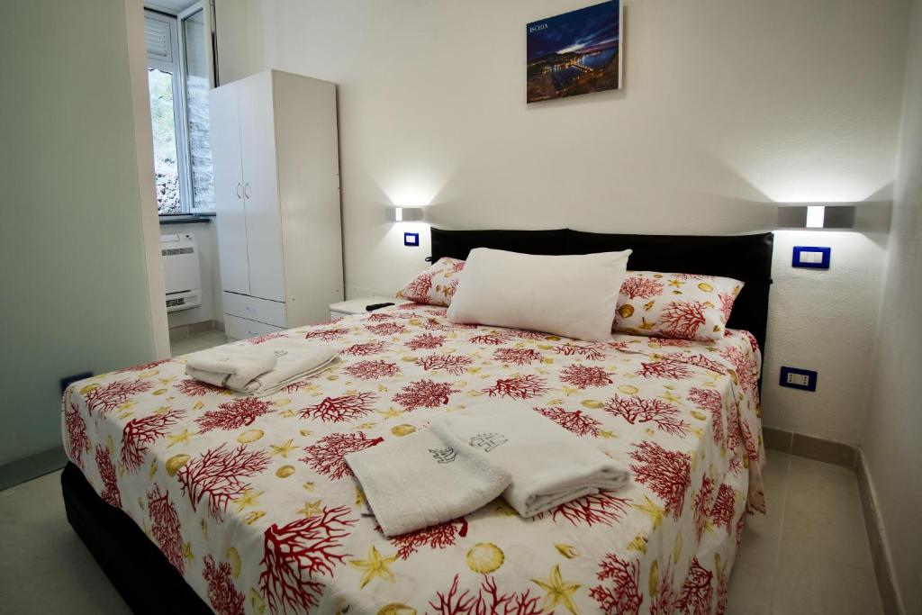 a bedroom with a large bed with towels on it at Ambra Apartment in Ischia