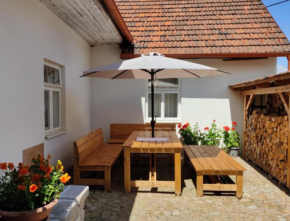 a wooden table with an umbrella on a patio at Chalupa v Okrouhlé Radouni 