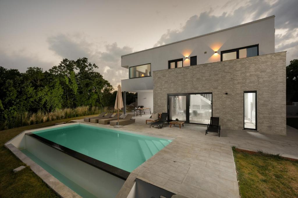 a house with a swimming pool in front of it at Sea View Villa Cala Royal in Krnica