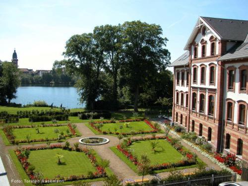 a garden in front of a building next to a building at Hotel Am Tiefwarensee in Waren