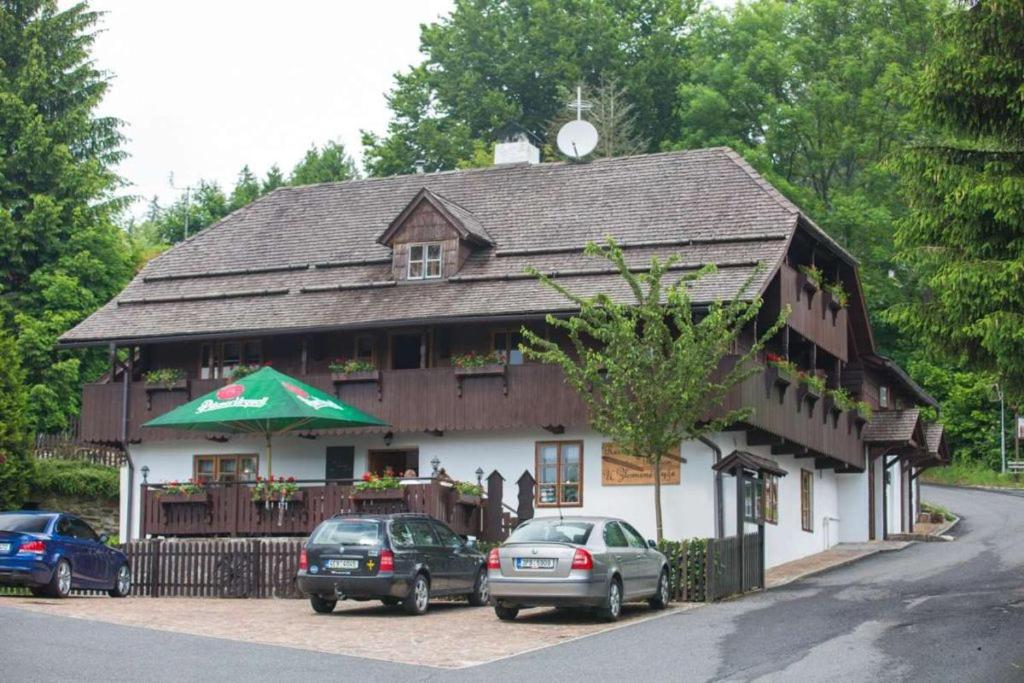 un bâtiment avec des voitures garées devant lui dans l'établissement Penzion U Zlomené lyže, à Železná Ruda