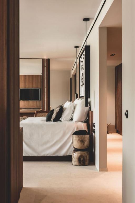 a bedroom with a bed with white sheets and pillows at OKU Ibiza in San Antonio