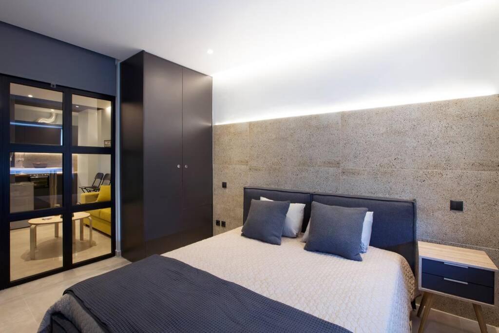 1 dormitorio con 1 cama grande con almohadas azules en City Center Modern Renovated Apartment en Athens