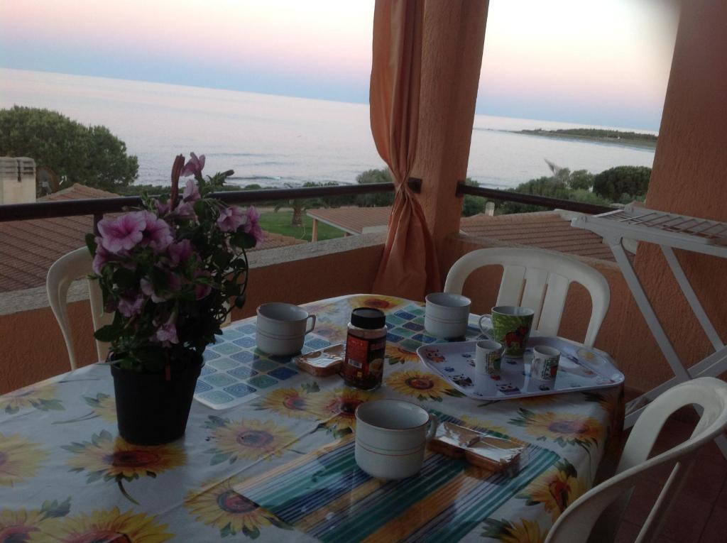 une table avec un vase de fleurs sur un balcon dans l'établissement Terrazza sul mare, à Villaputzu