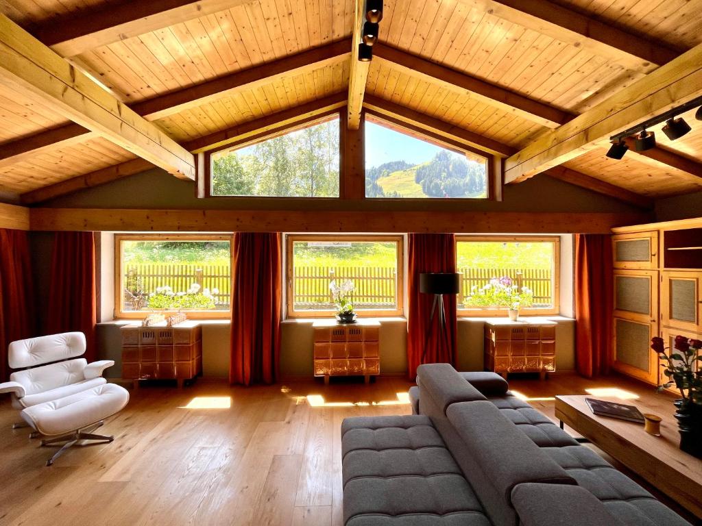 a living room with a couch and some windows at Kitzbühel Beach Chalet " Ski-in & Ski-out " in Kitzbühel