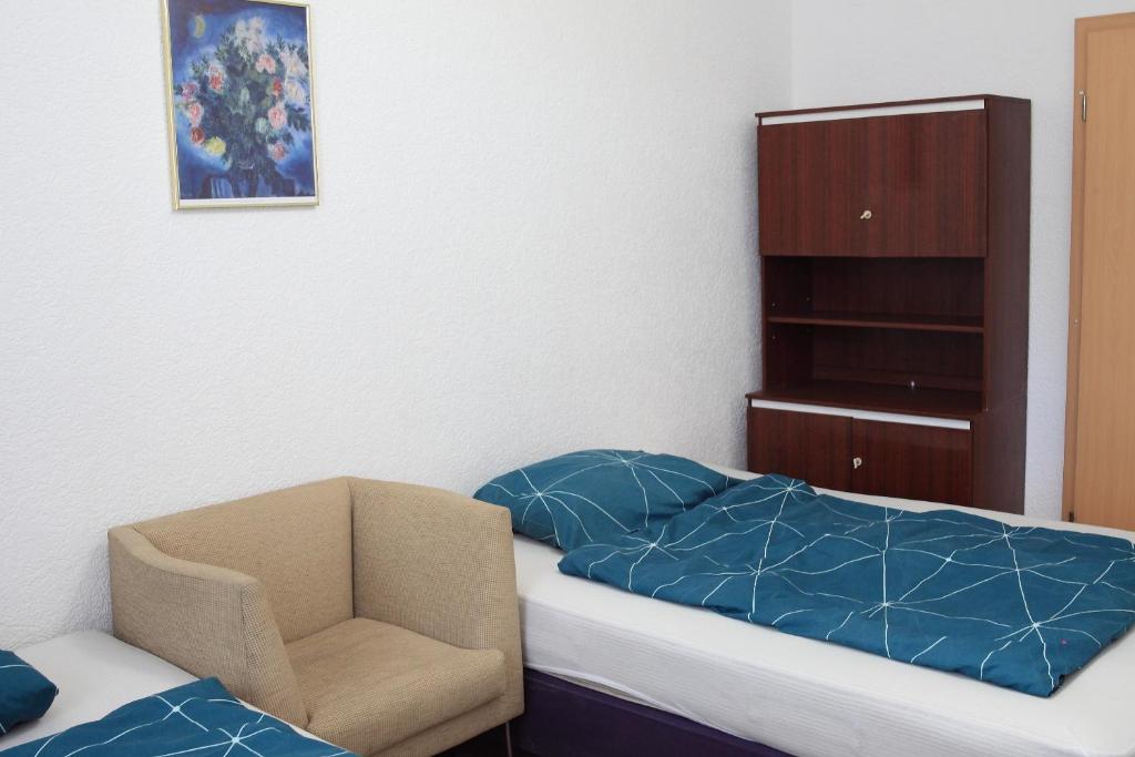 a small bedroom with a bed and a chair at Leuna - Mechanicsville in Bad Dürrenberg