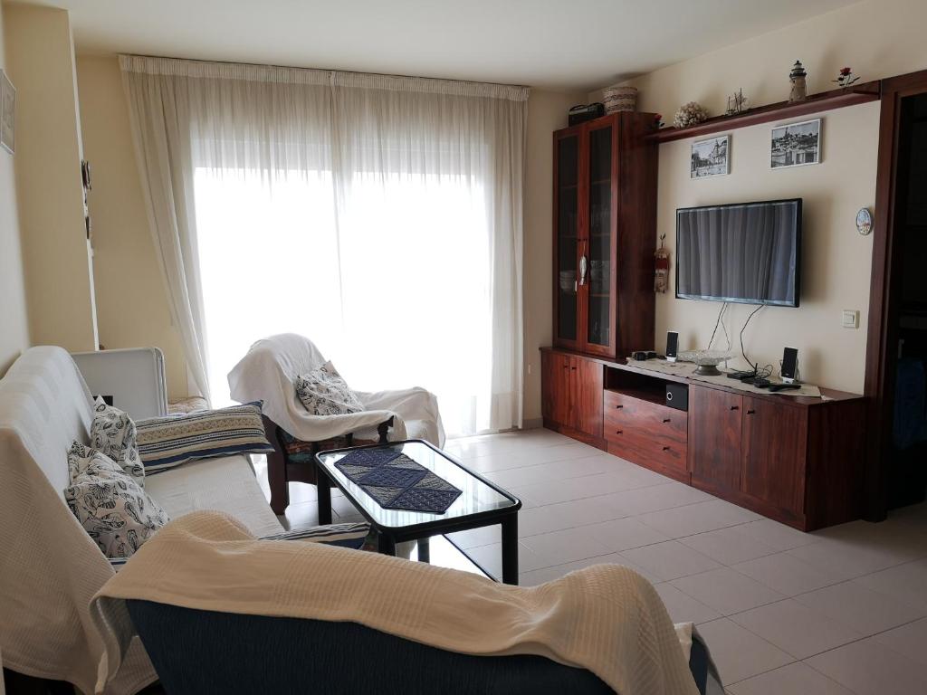 Televízia a/alebo spoločenská miestnosť v ubytovaní LLOGUER30 Apartamento Lotus, piscina y parquing