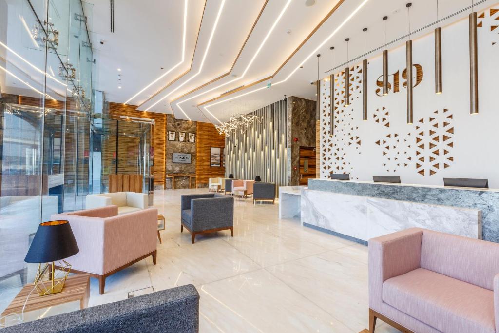 a lobby of a building with chairs and tables at S19 Hotel-Al Jaddaf Metro Station in Dubai