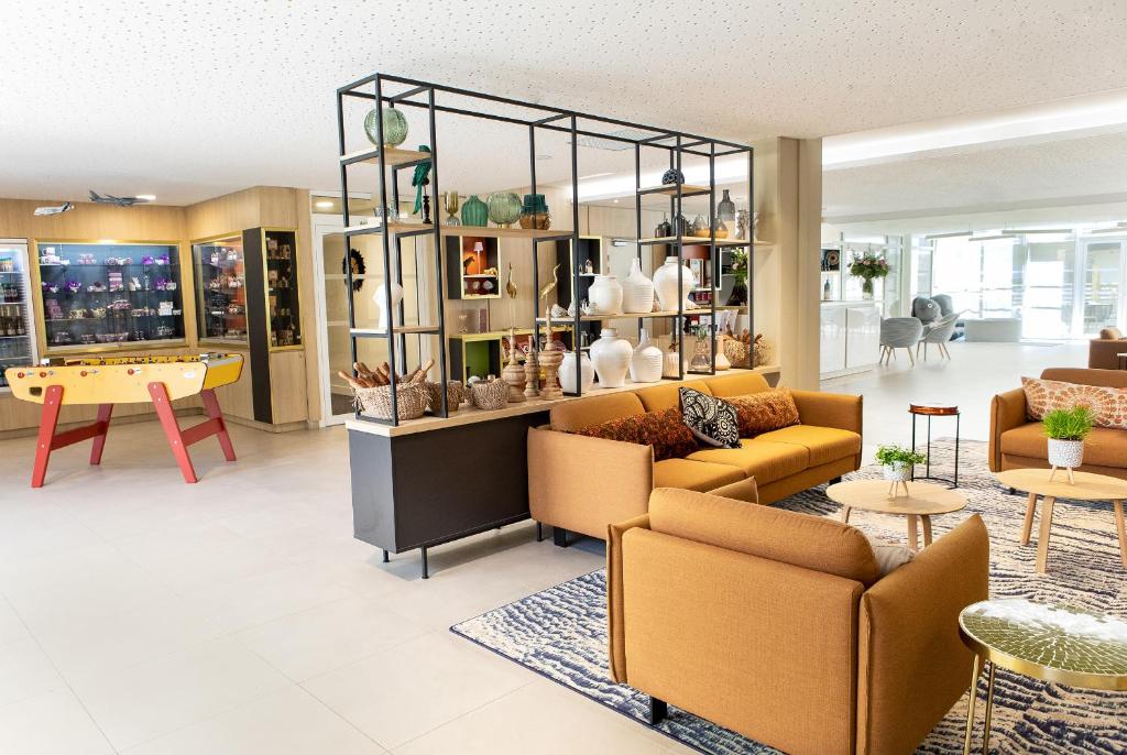 a living room with couches and a table and chairs at Residhome Toulouse Ponts Jumeaux in Toulouse