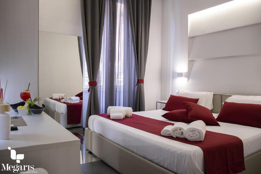 a bedroom with two beds with red and white pillows at Megaris Luxury Suite Rooms in Naples