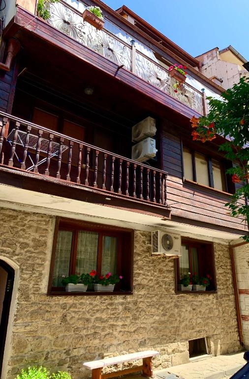 a building with a balcony and potted plants on it at Boutique House Belevi in Nesebar