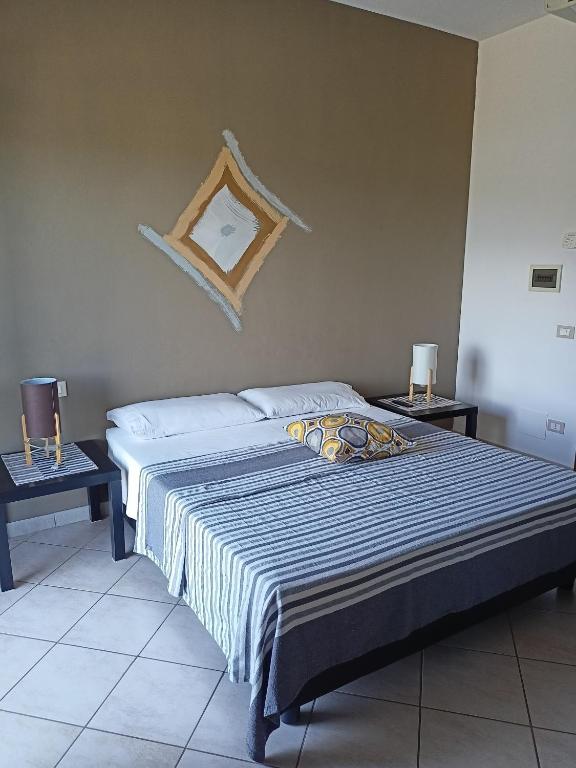 una camera da letto con un grande letto con due tavoli di Il Faggio 17 B&B ad Artena