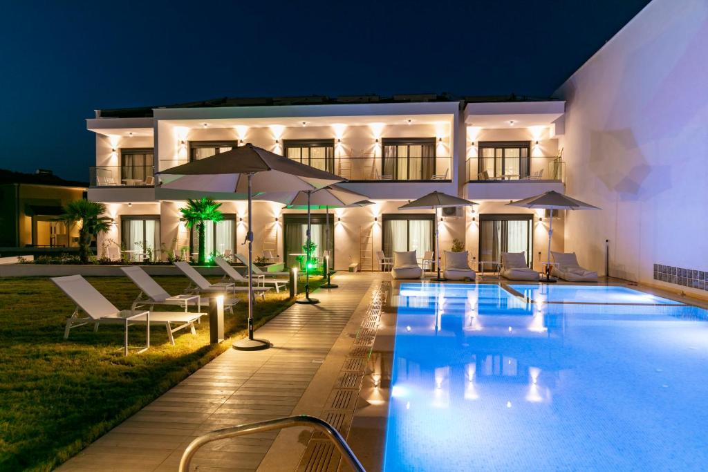 a villa with a swimming pool at night at B&D Luxury Suites in Skala Potamias
