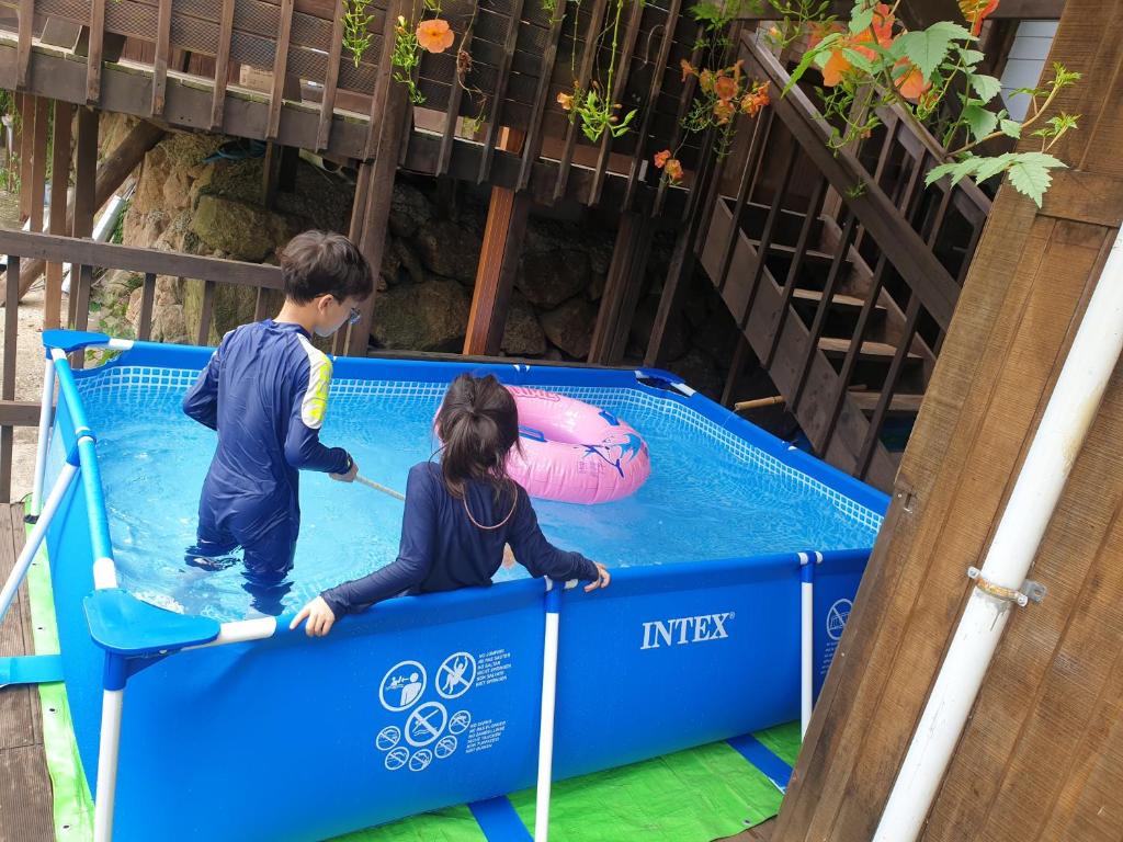 求禮郡的住宿－吉利桑一晚兩天度假屋，男孩和女孩在游泳池玩蹦床
