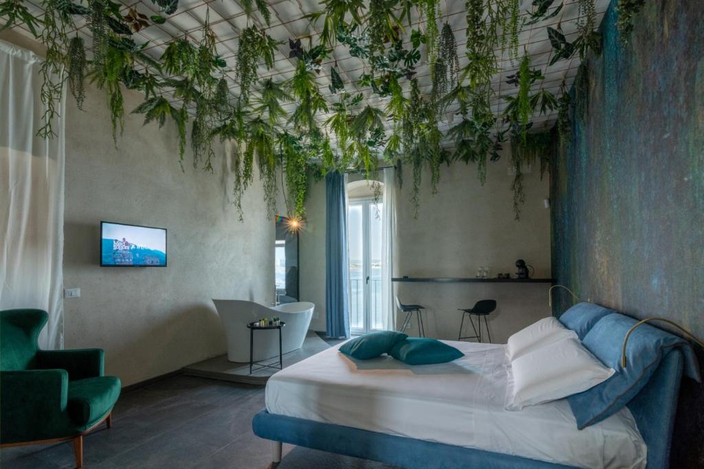 una camera da letto con un letto e piante sui soffitti di Sonrisa suites a Taranto