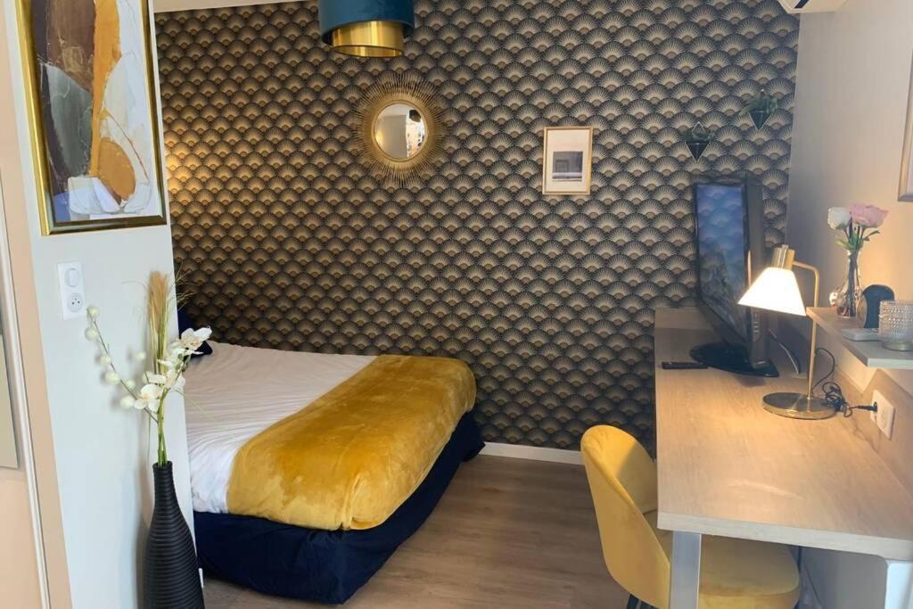 ein Schlafzimmer mit einem Bett und einem Schreibtisch mit einem Schreibtisch in der Unterkunft Joli appartement haut standing en hyper centre in Toulouse