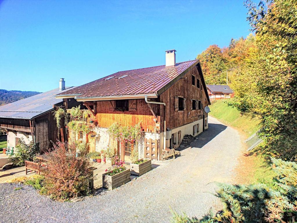 een groot houten huis met een weg ervoor bij Beautiful renovated chalet near ski resort France in Arâches-la-Frasse