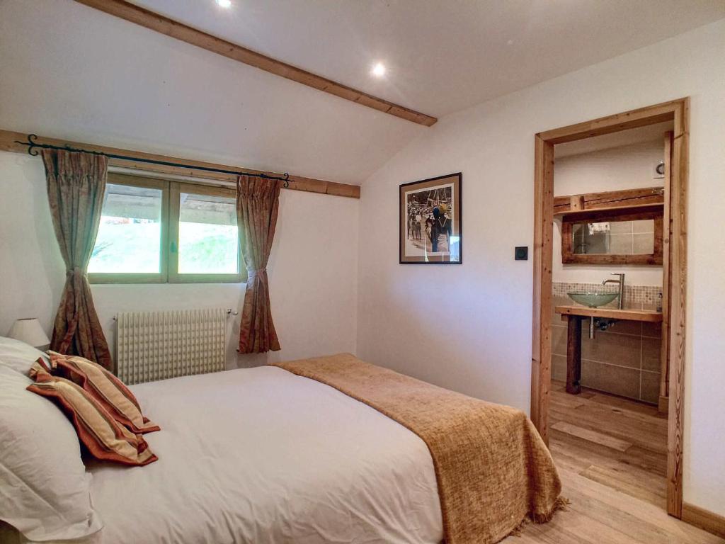 a bedroom with a large bed and a window at Beautiful renovated chalet near ski resort France in Arâches-la-Frasse