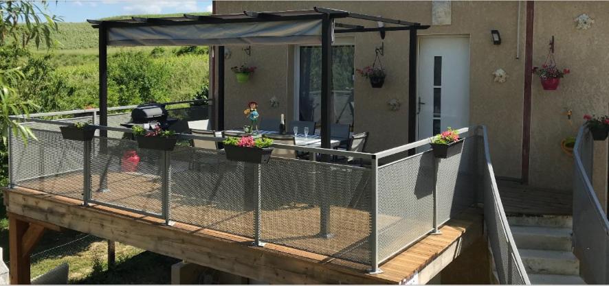 a deck with potted plants and a fence at Gite Du Clos Pommier in Chavot-Courcourt