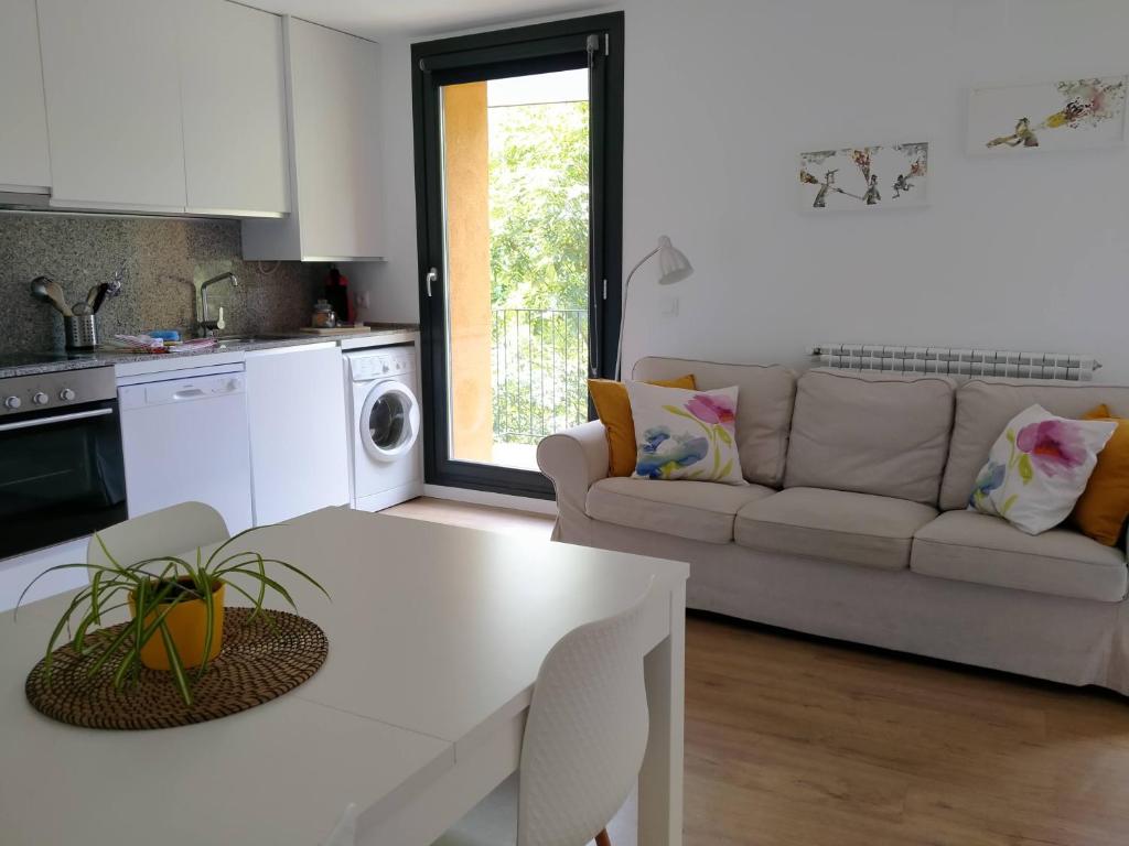 a white living room with a couch and a table at Ca de Géraldine in El Pont de Suert