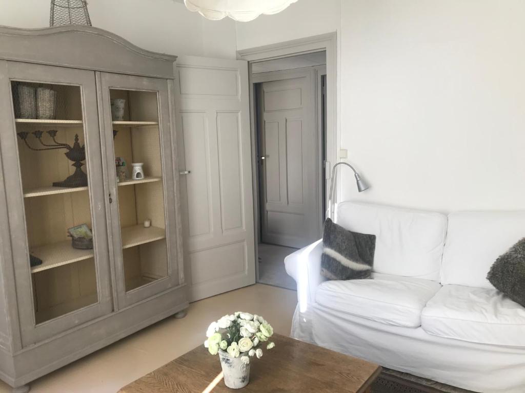 uma sala de estar com um sofá branco e uma mesa em Appartement en coeur de ville 2 à 4 personnes em Bort-les-Orgues