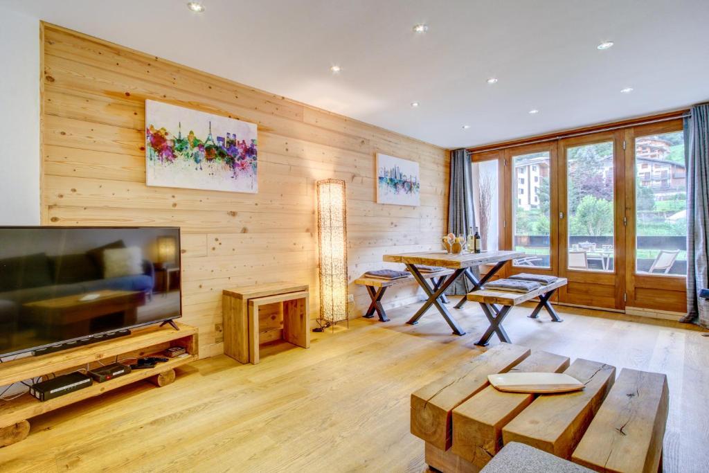 uma sala de estar com uma televisão e uma mesa em Le Jangilau em Morzine